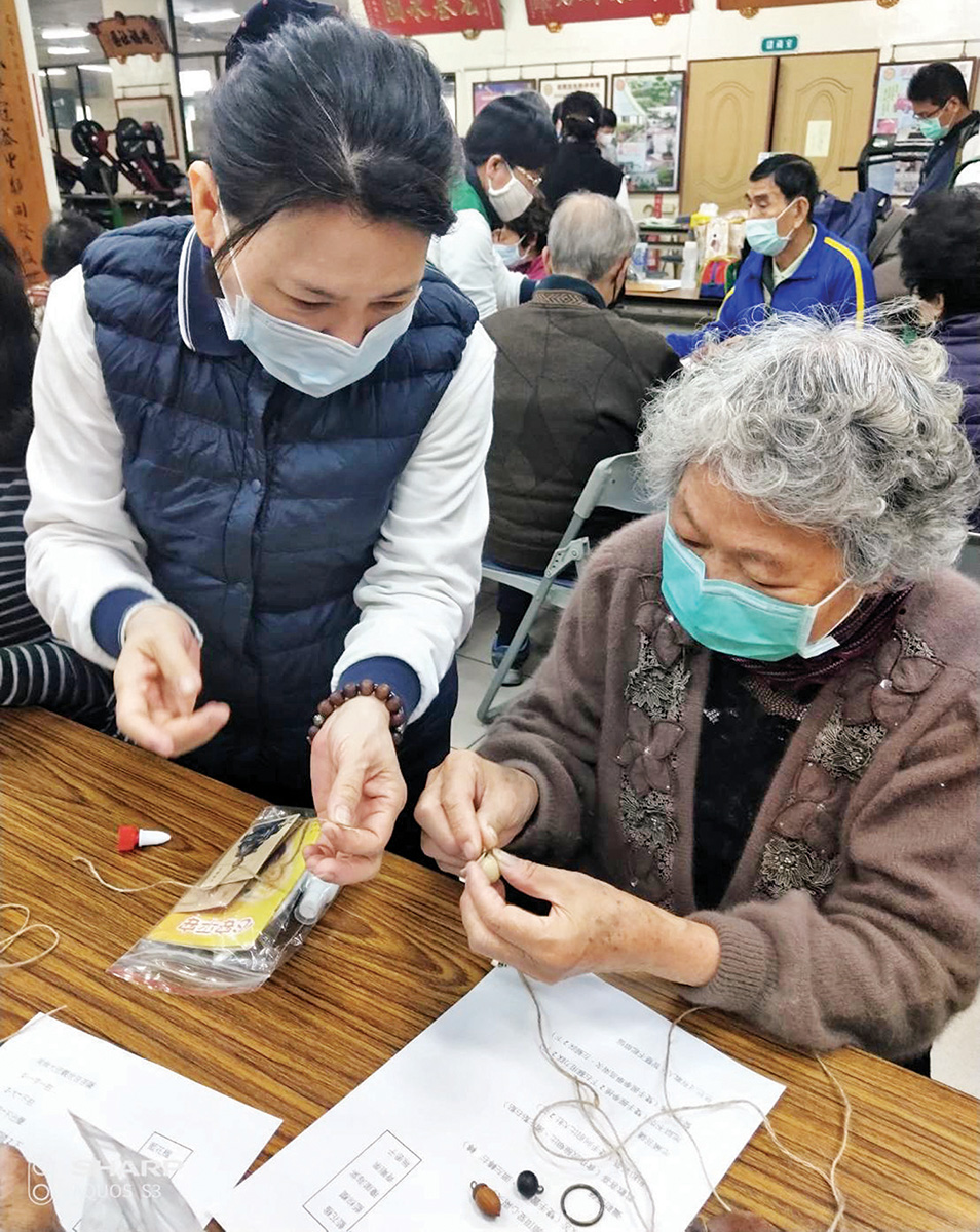 慈基會於臺南文南社區關懷長者，宣導正確的防疫觀念與方法，義工並帶領長者製作種子鑰匙圈。（慈基會 提供） 